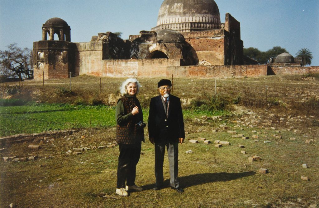 a woman and a man standing in front of a mosque