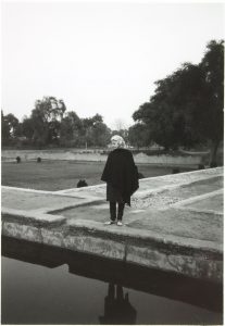 photograph of a woman standing near a pool of water