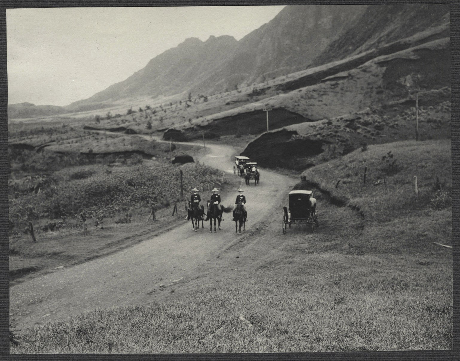 Soldiers on horseback escorting carriages.