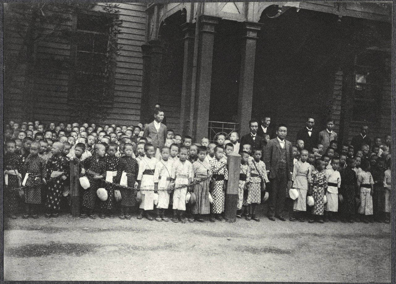 Japanese children and others standing along carriage route