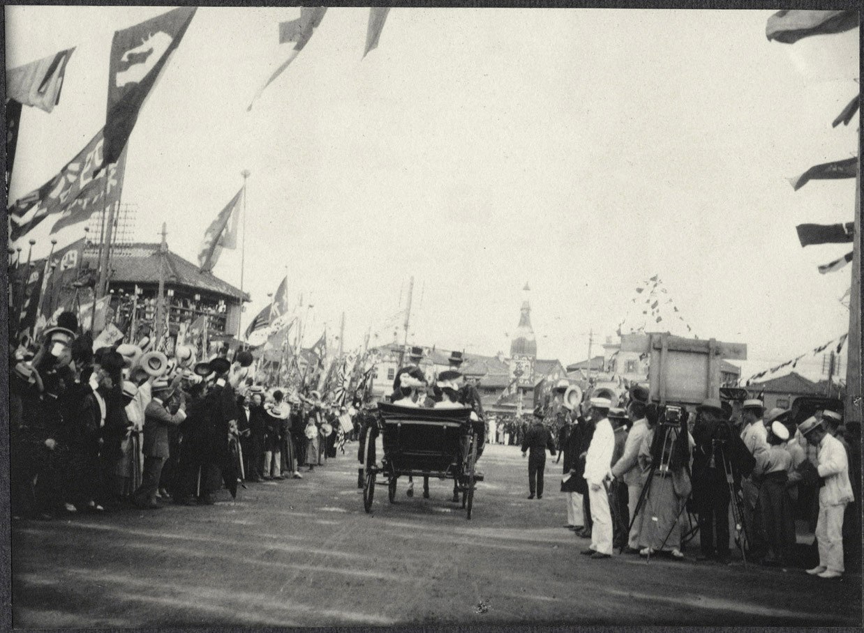 Tokyo: Alice Roosevelt in a carriage rides among flag waving crowds leaving Shinbashi Station