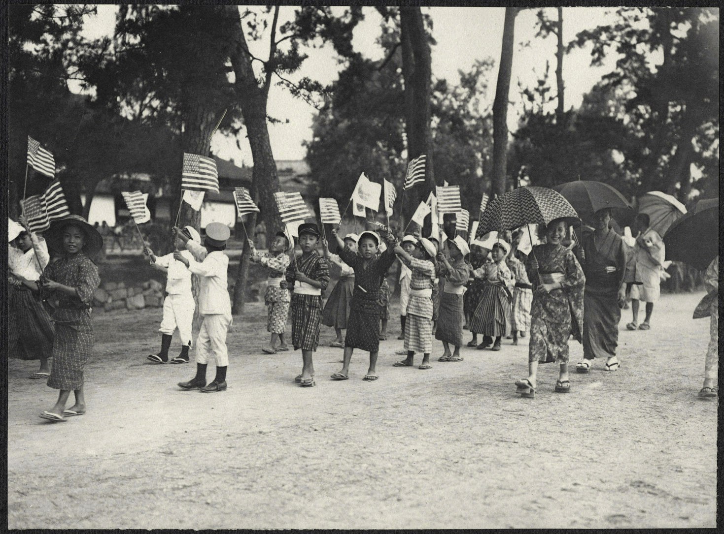 Japanese children parading with American and Japanese flags