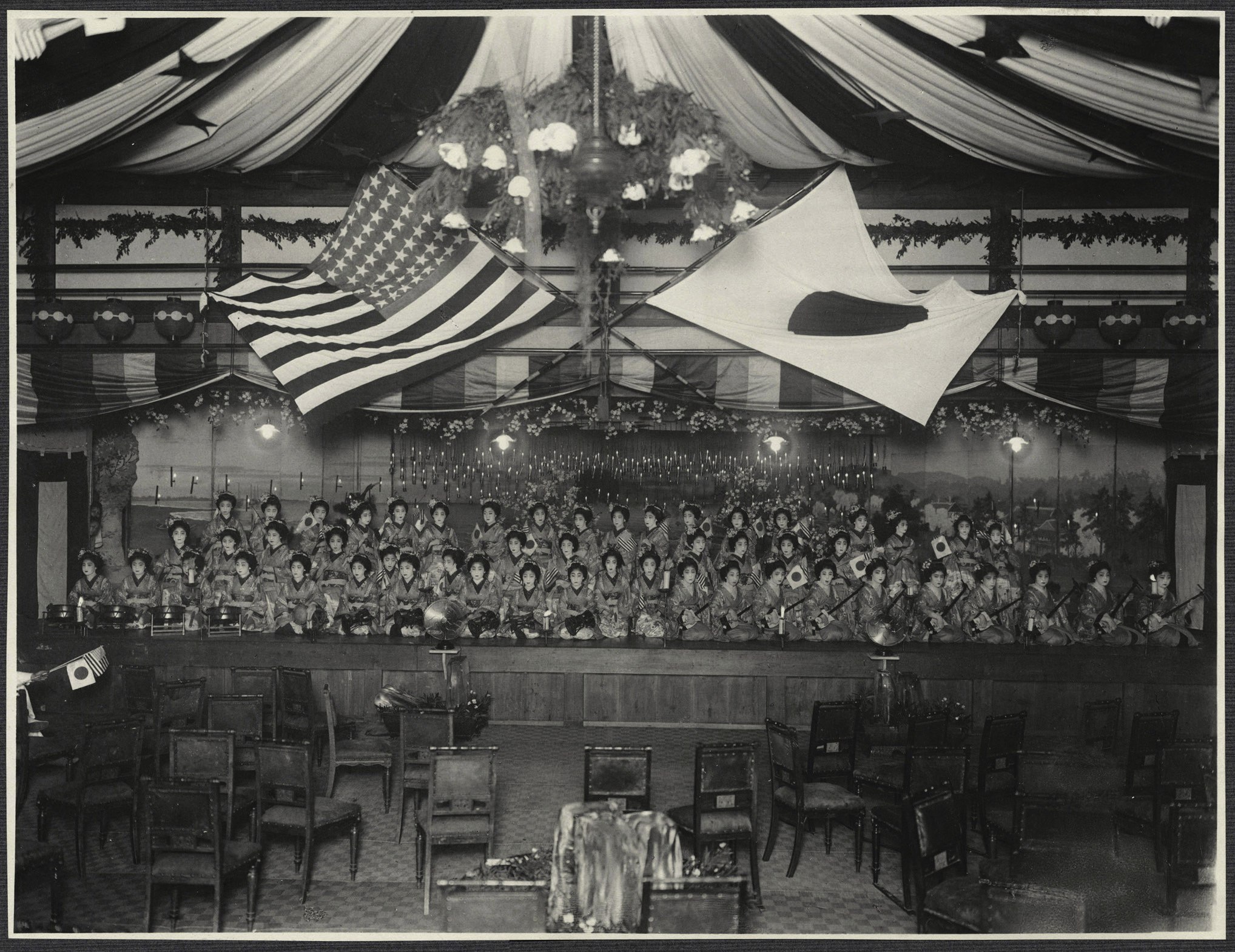 Female musicians on stage with Japanese and American flags, likely at a musical presentation hosted by the city of Kyoto