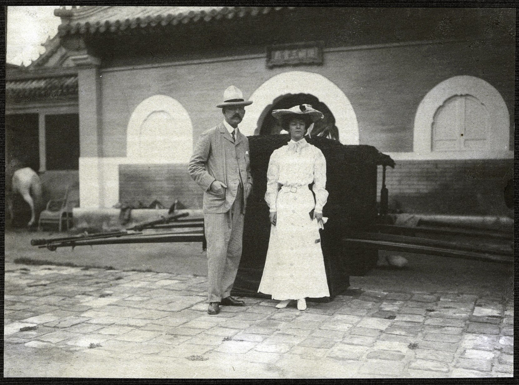 Beijing: Alice Roosevelt with American Minister to China, William Woodville Rockhill, standing in front of two palanquins