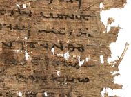 Fragmented, worn papyrus with faded writing in black ink