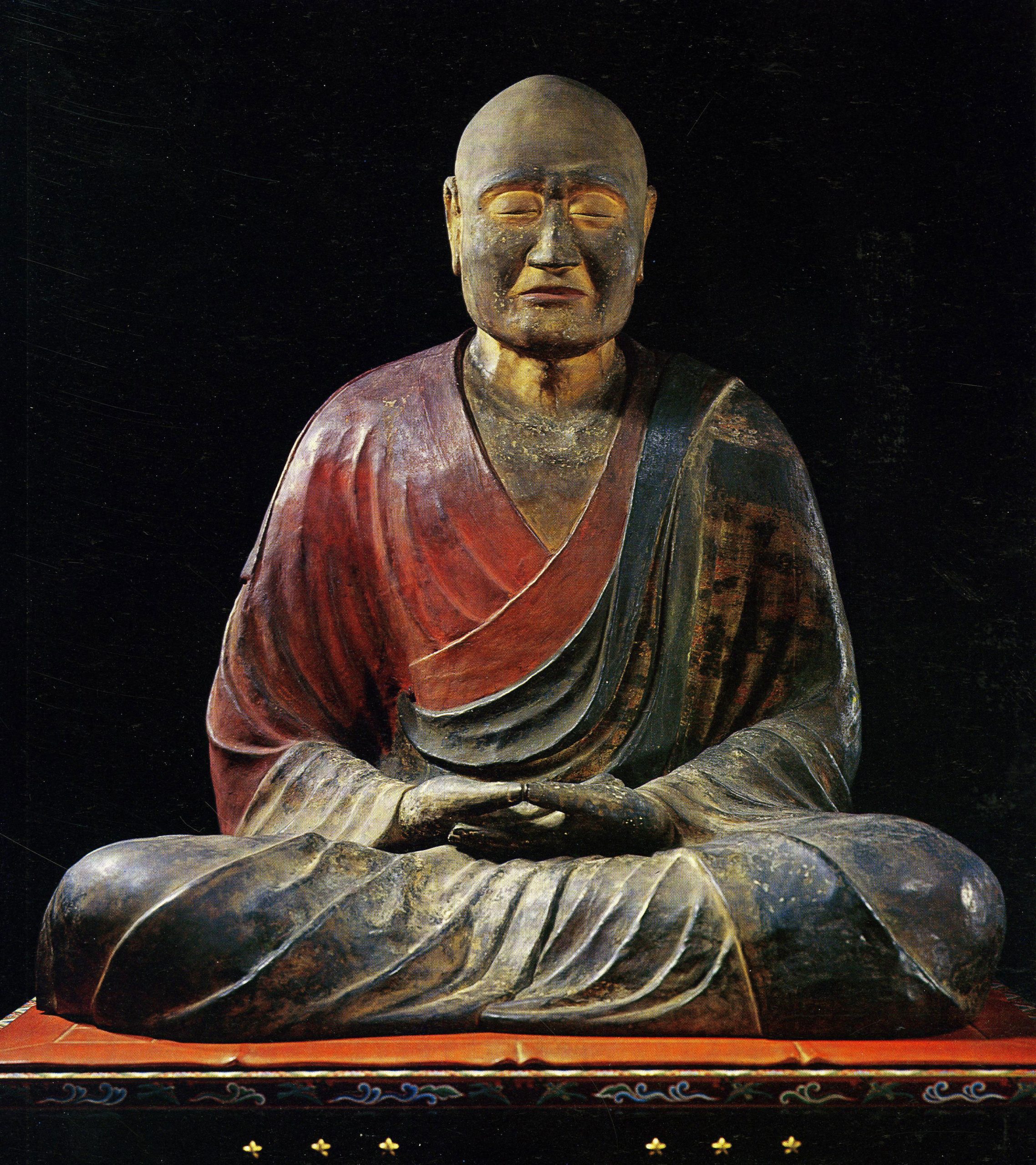 Sculpture of a monk, with some red and dark coloring