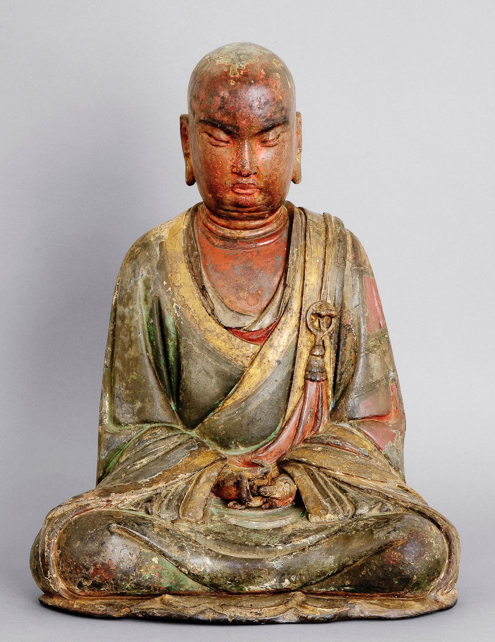 seated Luohan with a reddish face and greenish robes