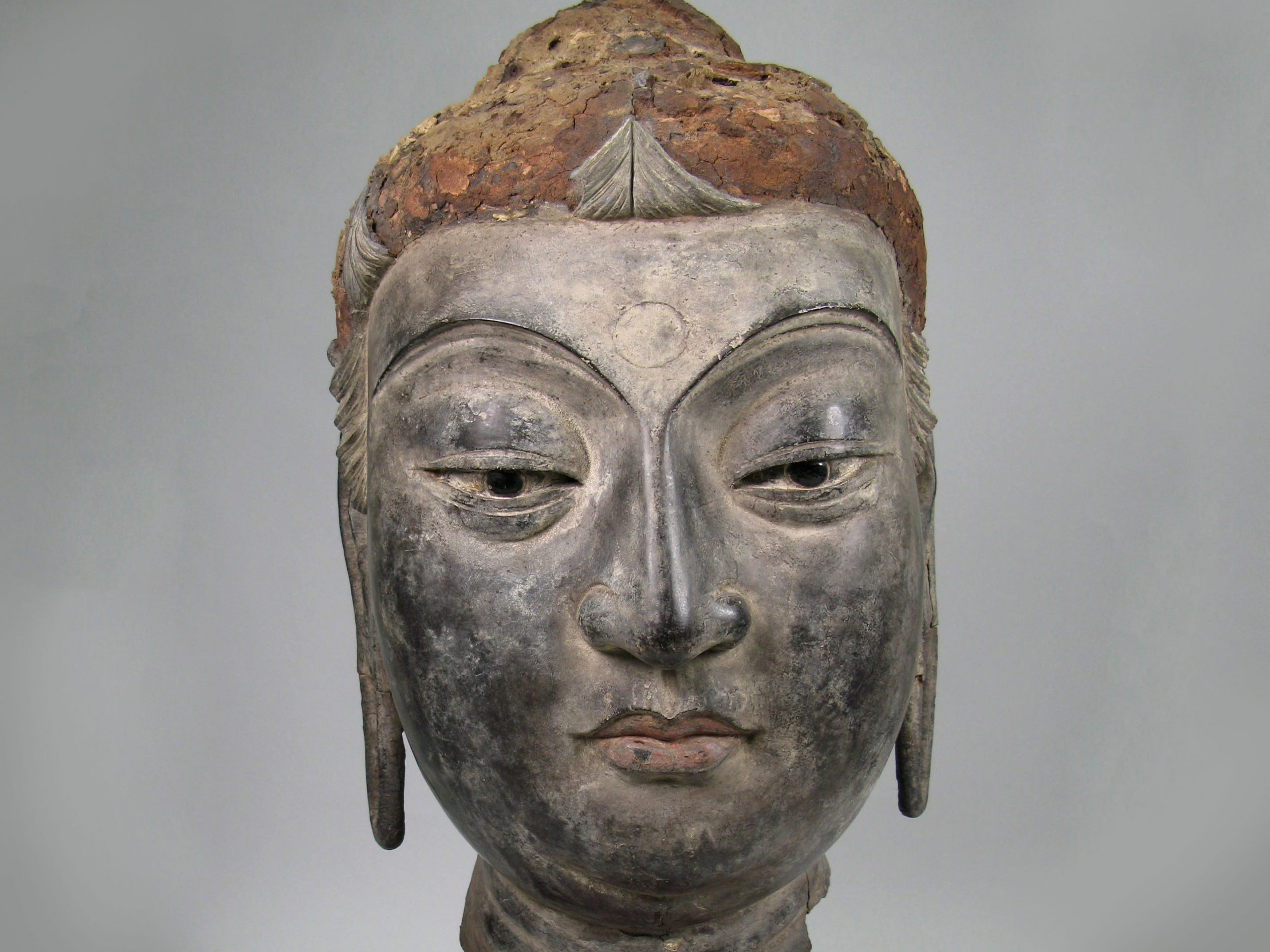 Statue of a head with large defined features.