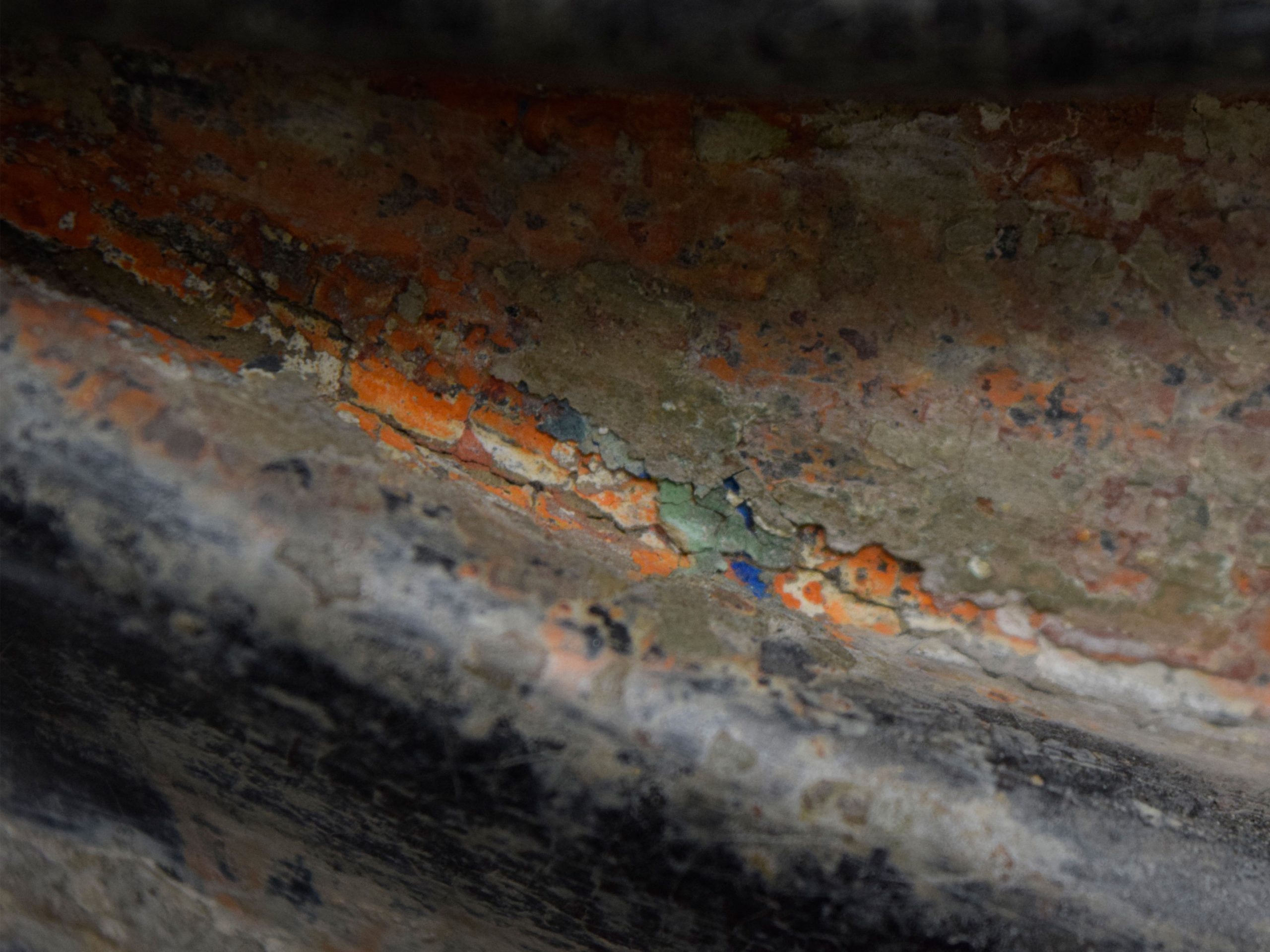 Close-up of peeling paint layers on the robe.