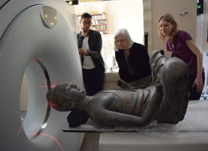Conservators look on as the Freer buddha goes into the CT scanning equipment