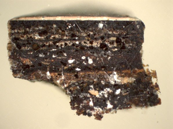 A dark-colored sample showing different layering of materials