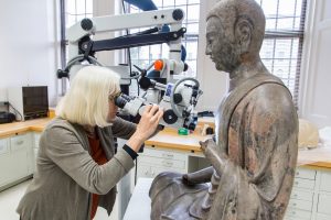 Looking at microscope at Freer Buddha