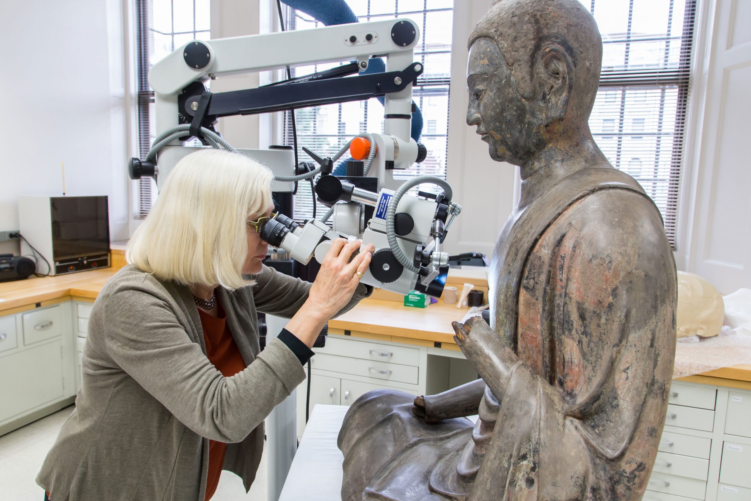 Looking at microscope at Freer Buddha