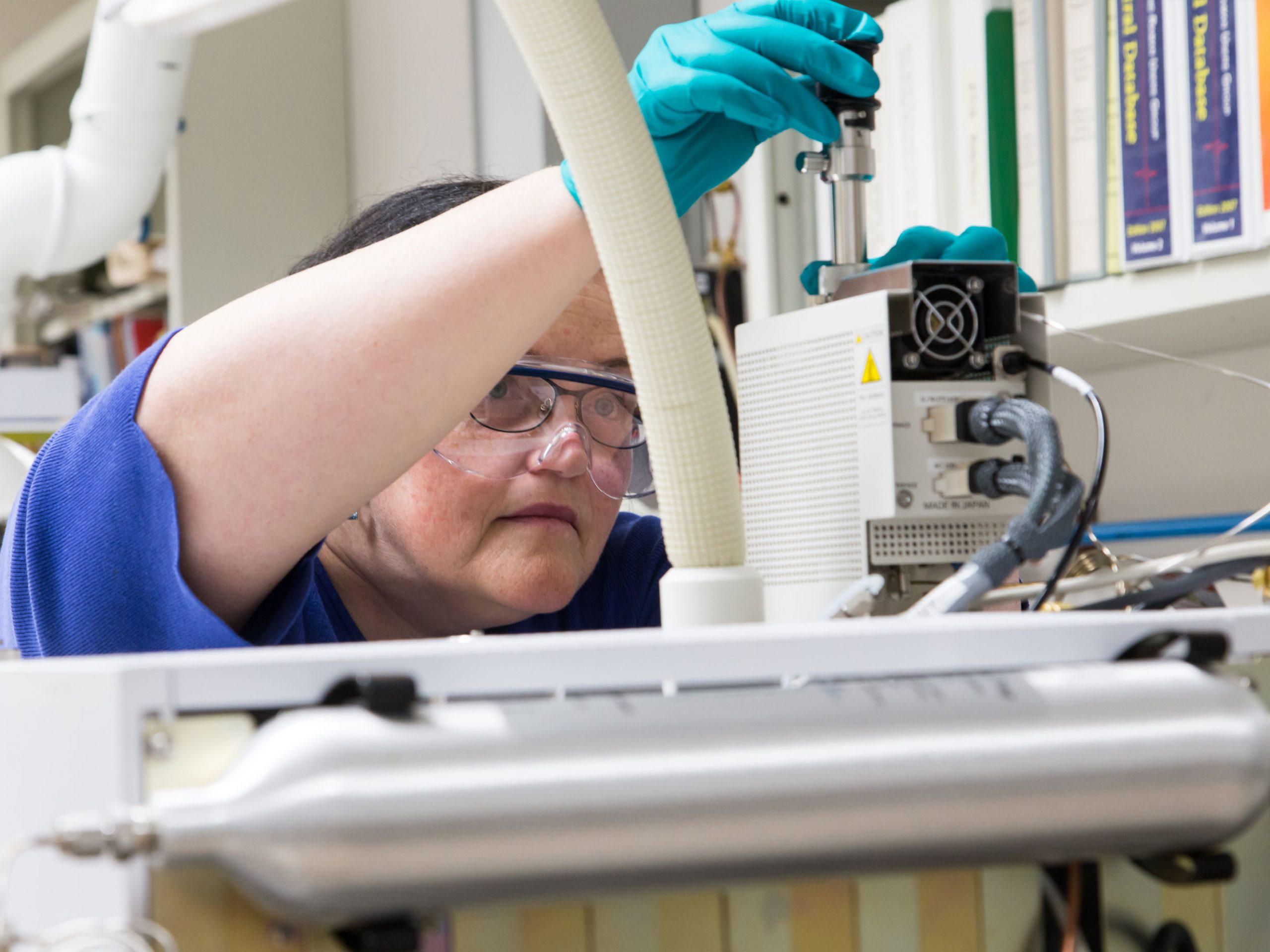 a conservator putting a sample into pyrolysis gas chromatography mass spectrometer for organic analysis.