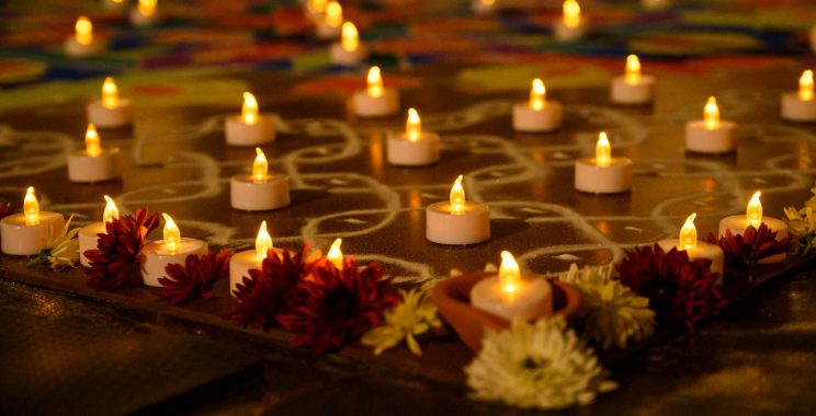 A close-up view of flowers and small votive candles arranged in a geometric pattern.