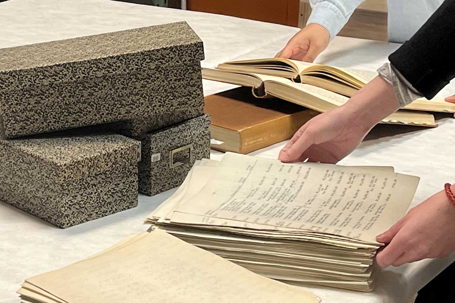 Hands handling archival papers.