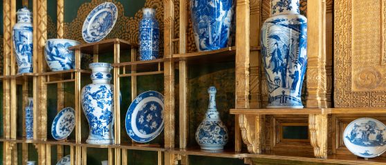 blue and white vases on gilded shelving in the green and blue peacock room