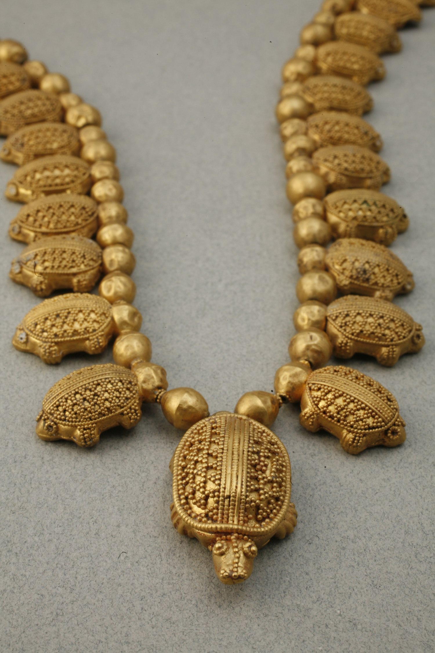 Thirty-one pendants in the form of charming turtles make up this necklace. The eyes of the thirty small ones were done with glass inlay, while those of the large one are of gold. The carapaces are decorated with granulation.