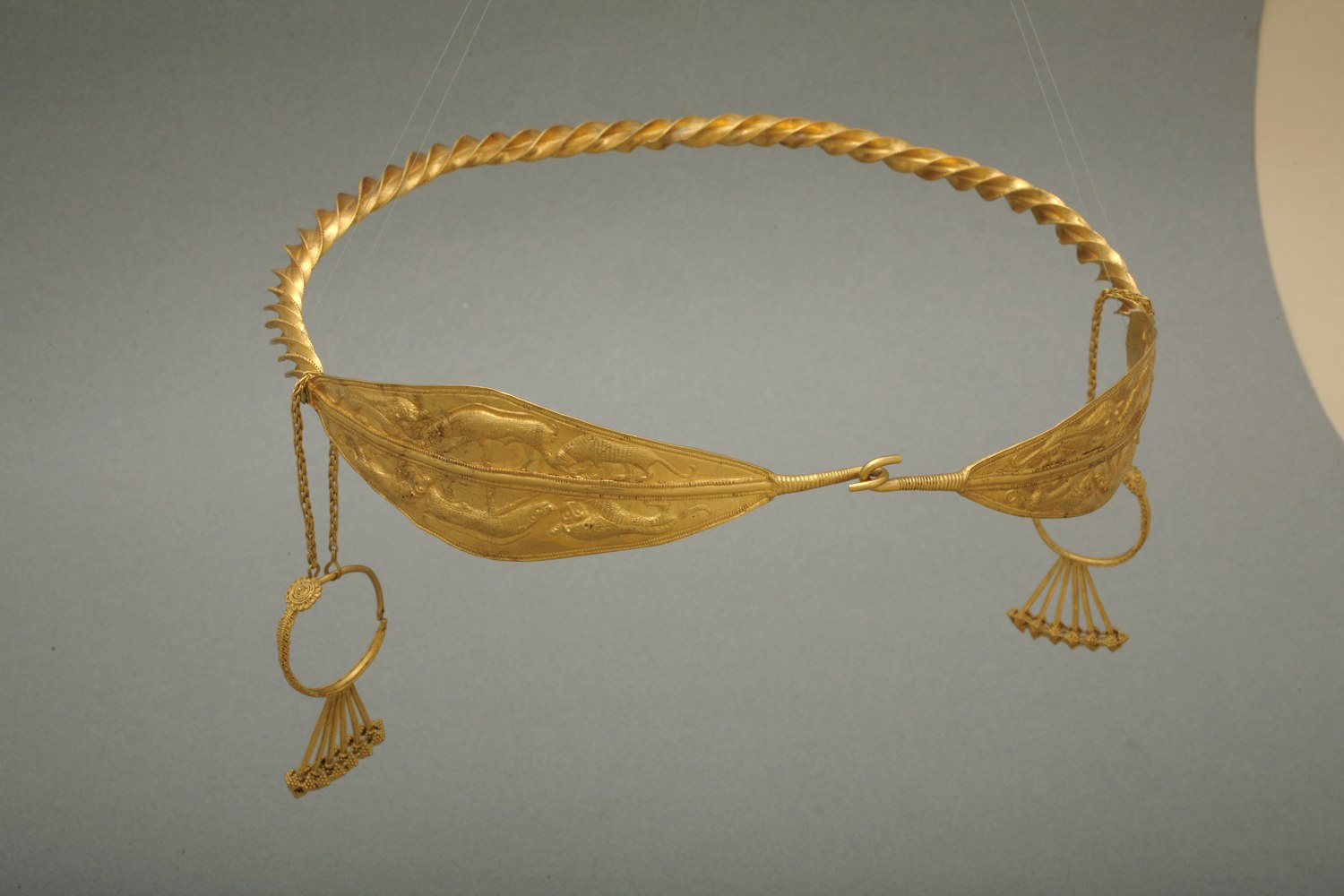 diadem decorated with repoussé panels of lions attacking wild boar. Its large size suggests that it was worn over a headdress, perhaps one made of cloth.