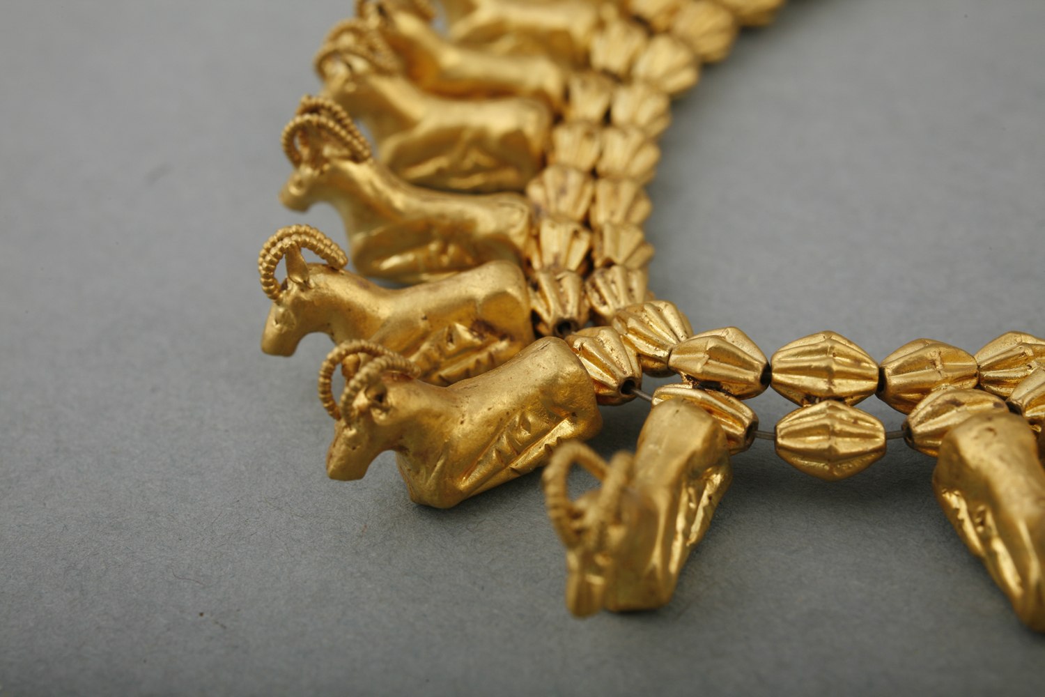 necklace with 56 crouching gazelles and 13 ribbed spacer beads. The animals were stamped in two halves and soldered together. Ears and horns were added separately.