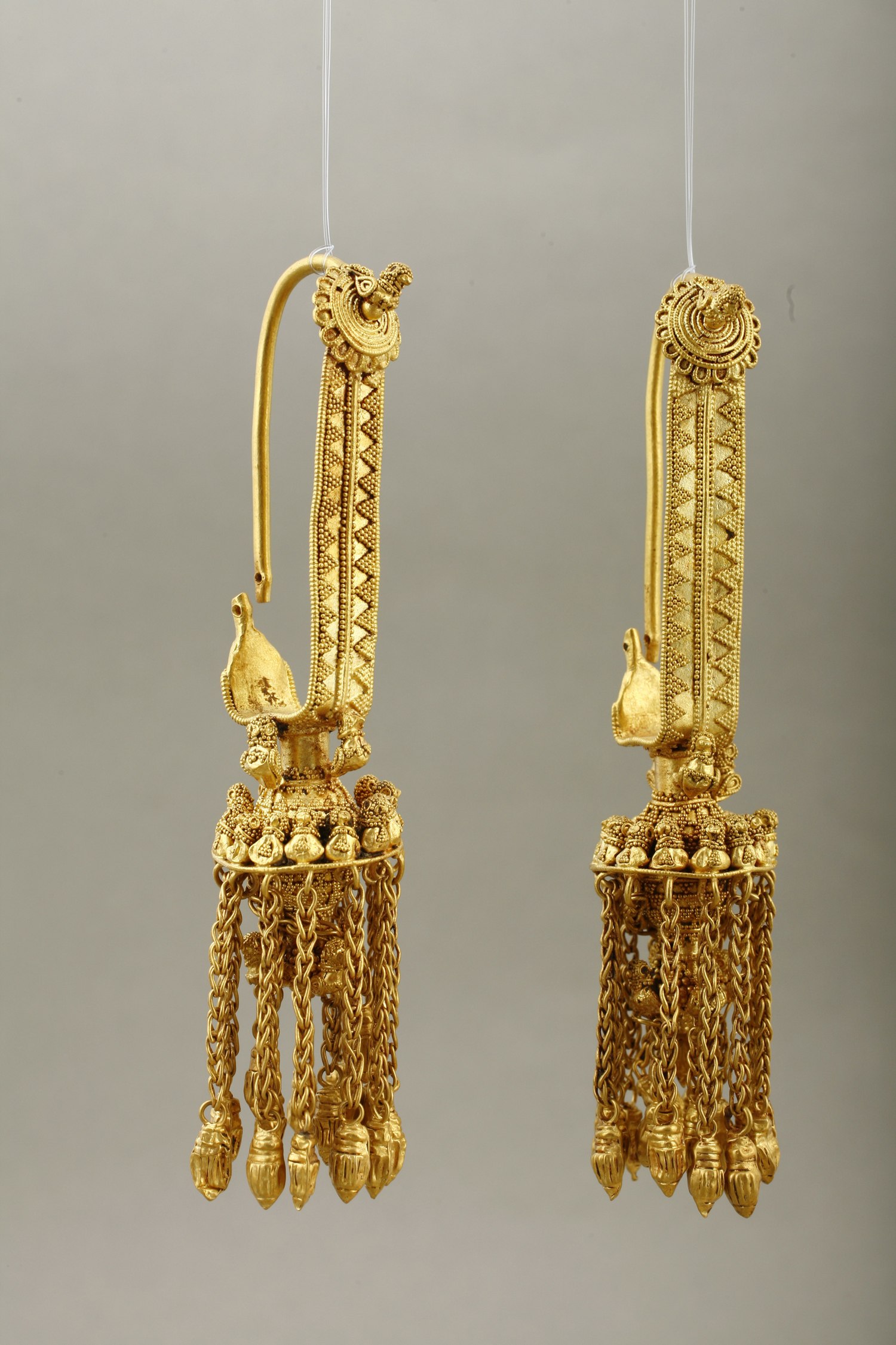 temple ornaments found at Vani. Birds constitute the predominant motif. They enliven the rosettes and appear at the junction of the frontal band to the pendant. A whole nest of birds is around the top of the pendant, and yet more hide behind the chains