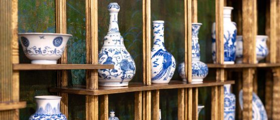 blue and white vases on gilded shelving in the green and blue peacock room