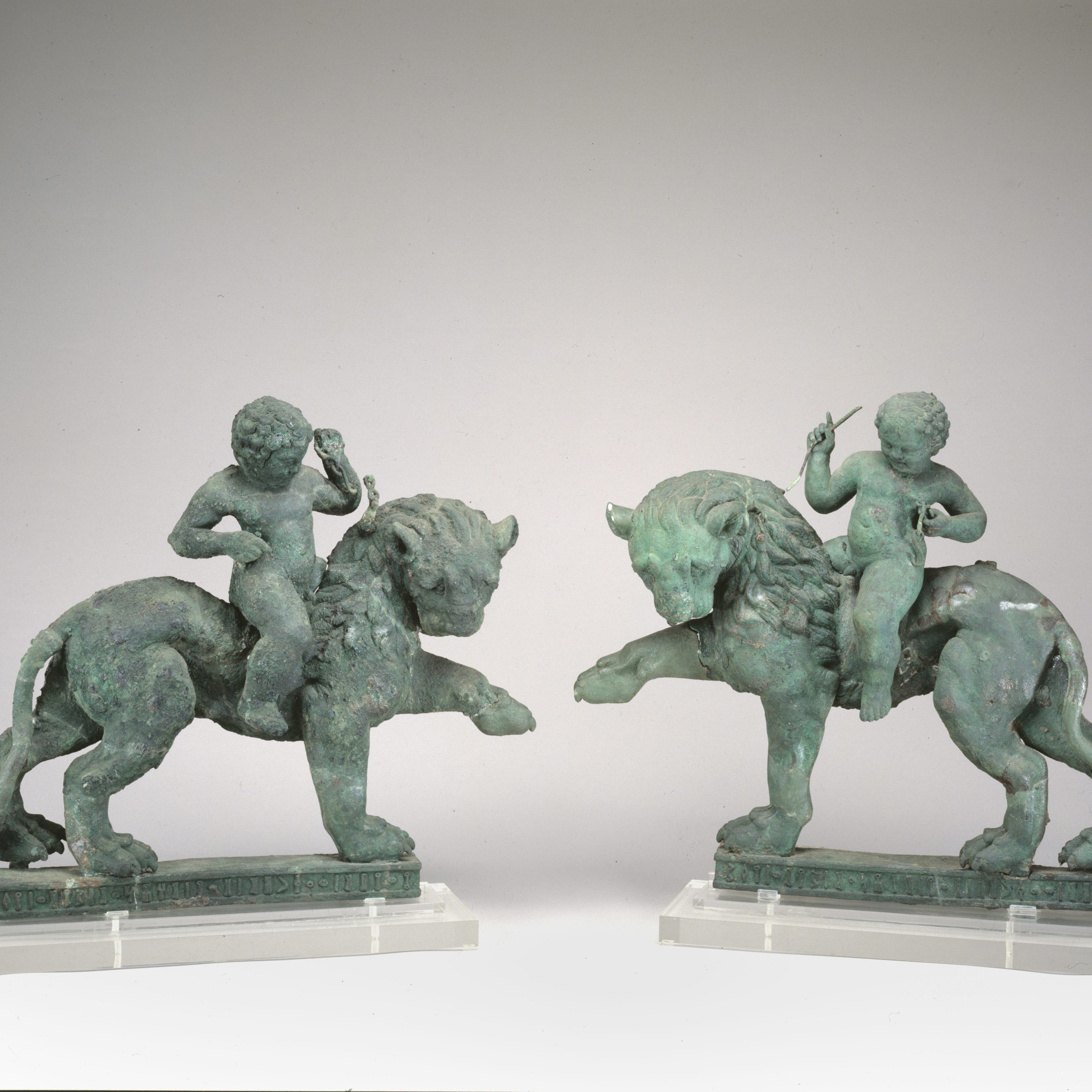 Bronze pair of lions with Cupids riders
