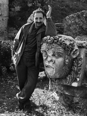 a photo of Ara Güler standing next to a sculpture of a head